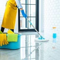 happy-young-woman-blue-rubber-using-mop-while-cleaning-floor-home