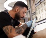 talented-tattoo-artist-doing-his-job-side-view