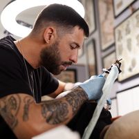 talented-tattoo-artist-doing-his-job-side-view